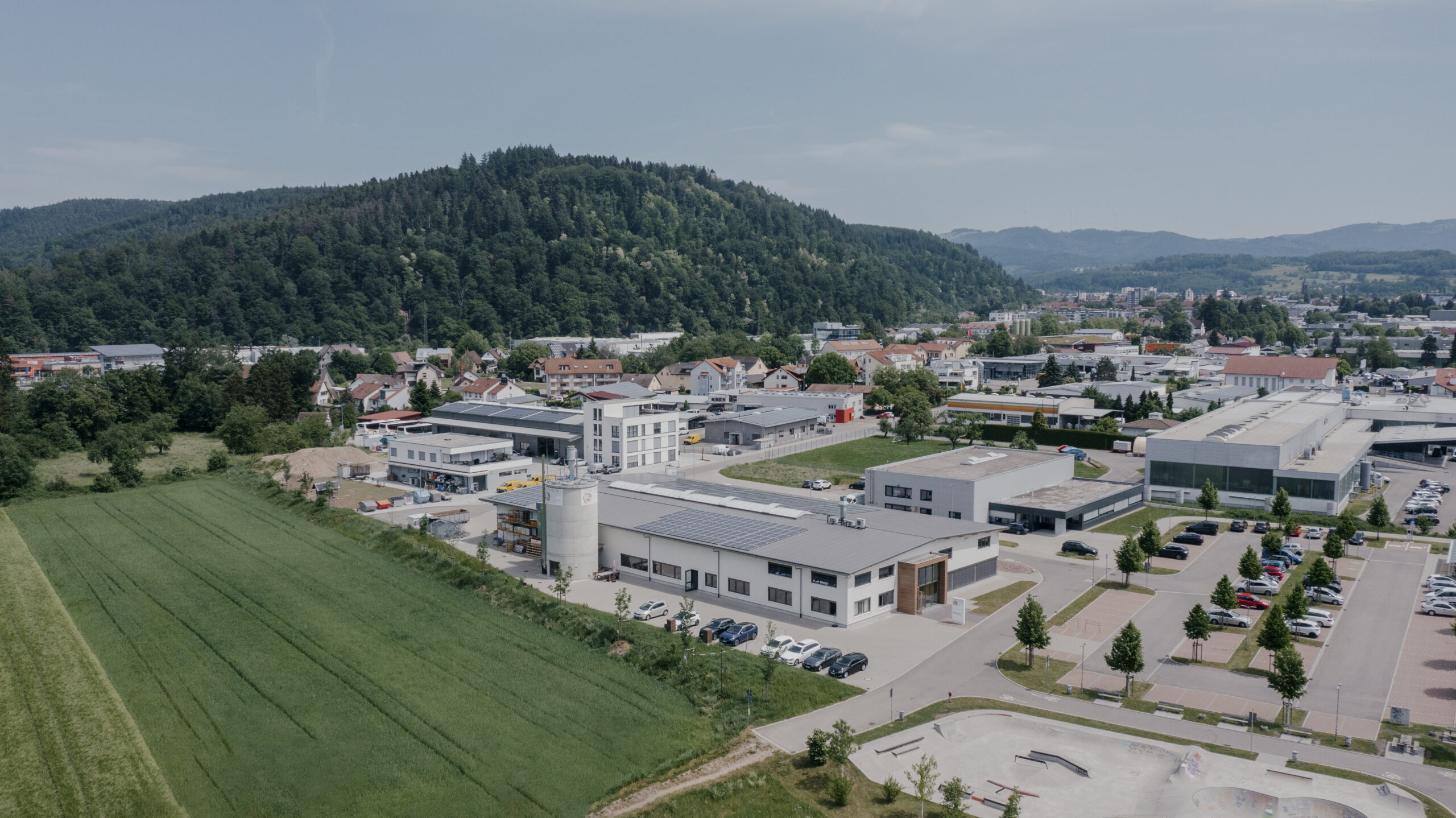 Firmengebäude Schreinerei APV Schopfheim, Blick von oben Drohnenbild mit einer Wiese rechts und bergen im Hintergrund